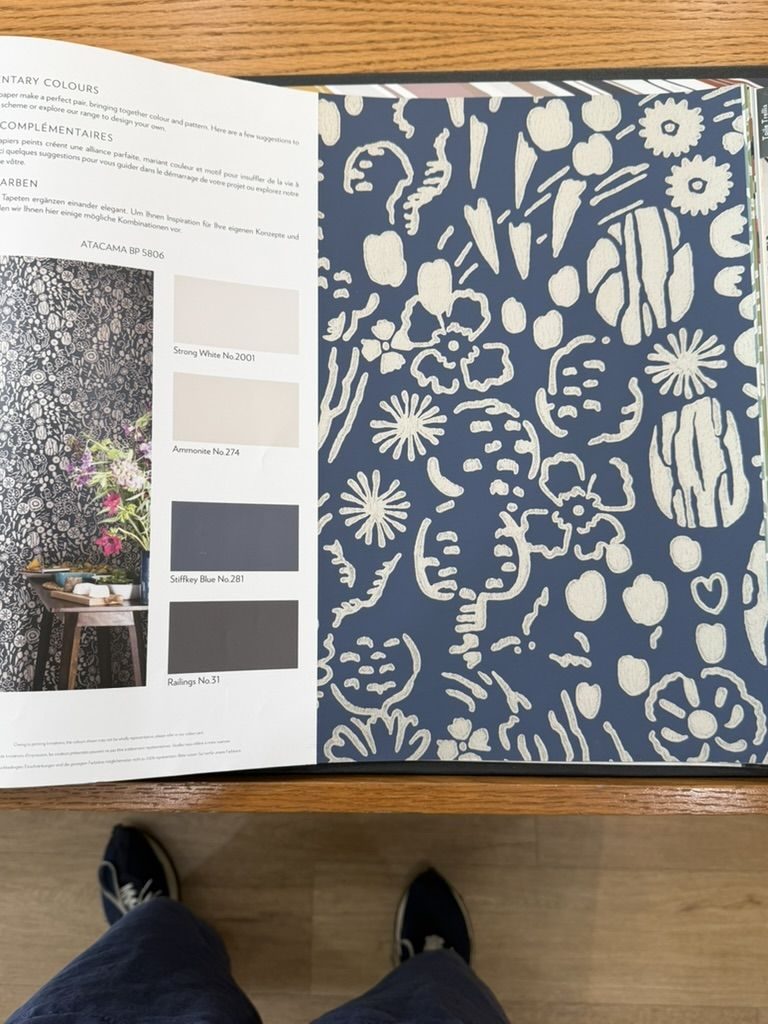 Farrow & Ball wallpaper book open to a navy floral