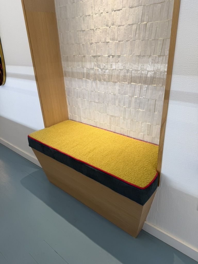 Built-in bench with mustard boucle cushion and pearl tile