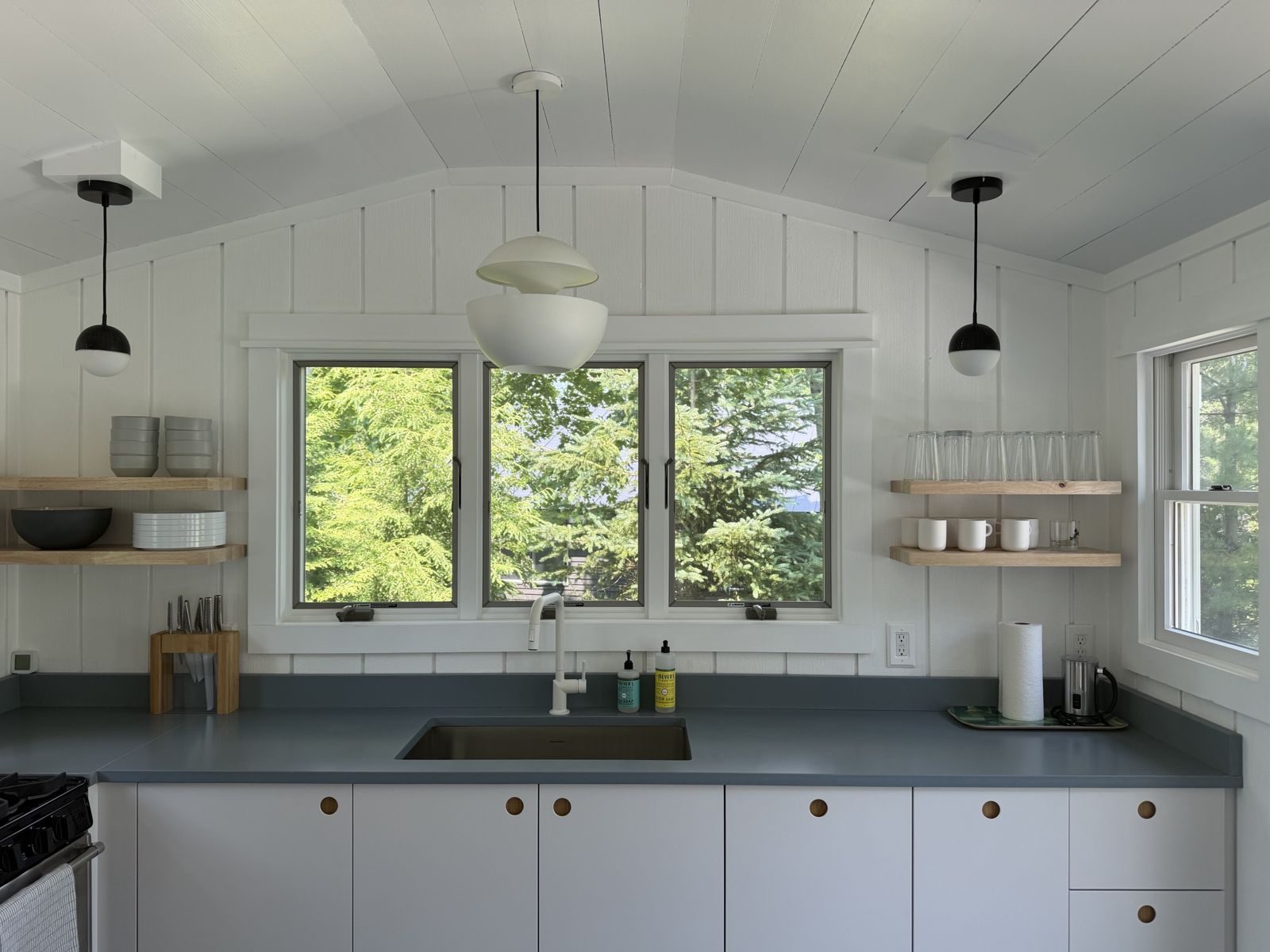 Wreck House kitchen with open oak shelves and blue counters