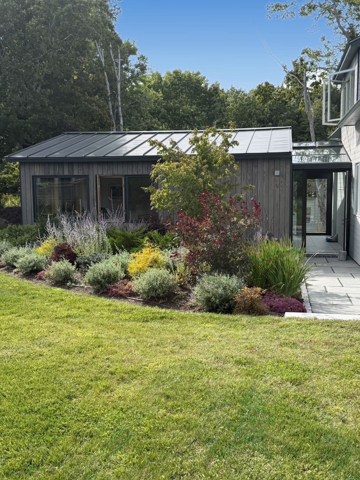 The Wreck Study and glass breezeway behind a perennial garden