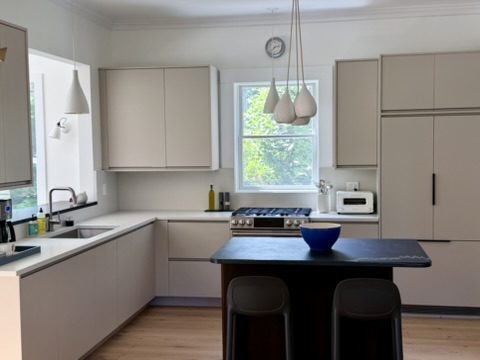 Kitchen with dark island and window over the stove