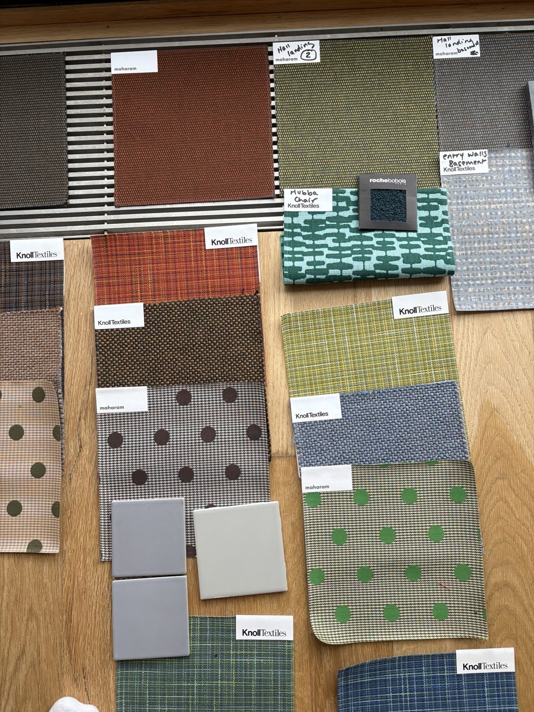 Maharam and Knoll textile swatches and tile samples labeled by room
