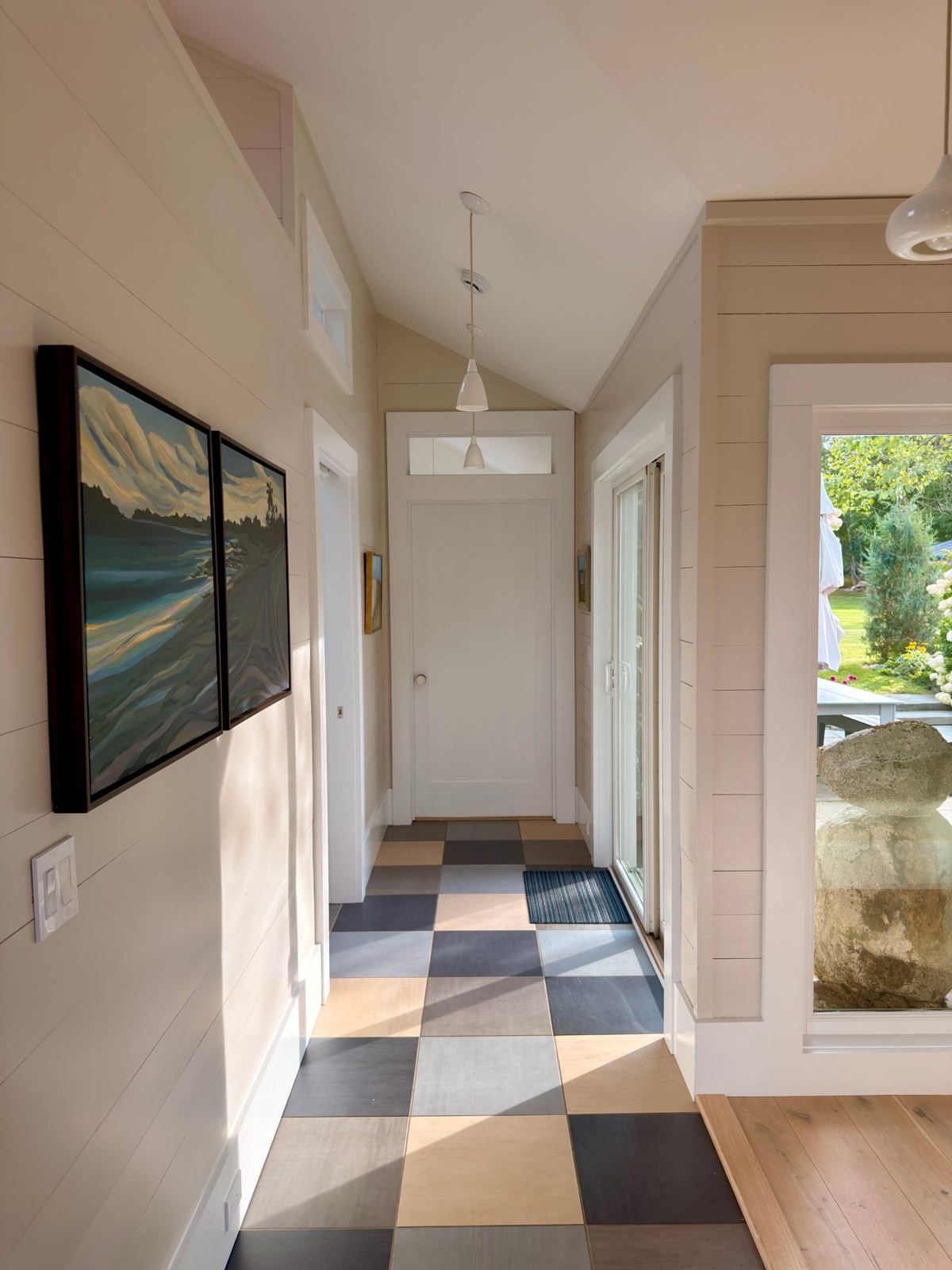 Hallway with checkered floor and seascape paintings